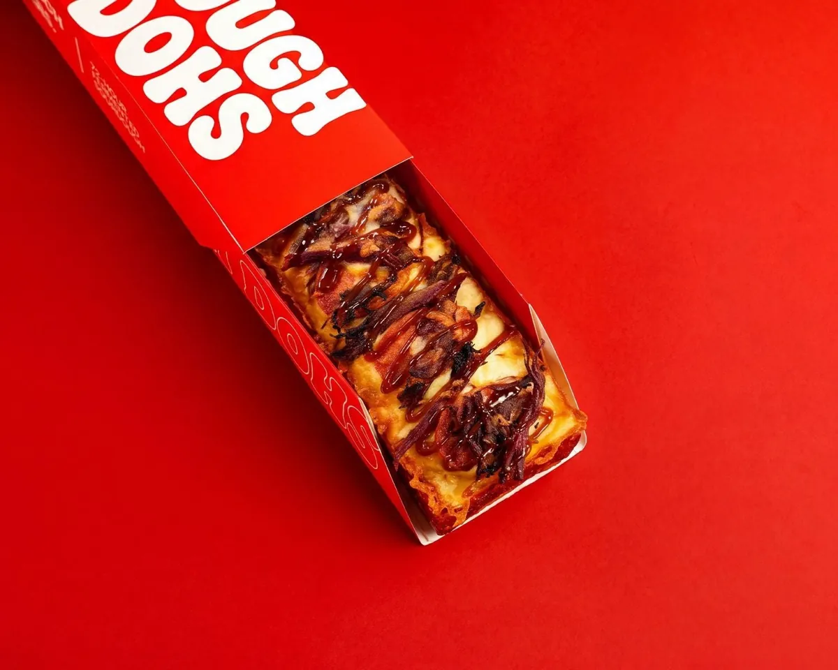 Dough Dohs Carnivore pizza with meat toppings and BBQ glaze in a branded red box